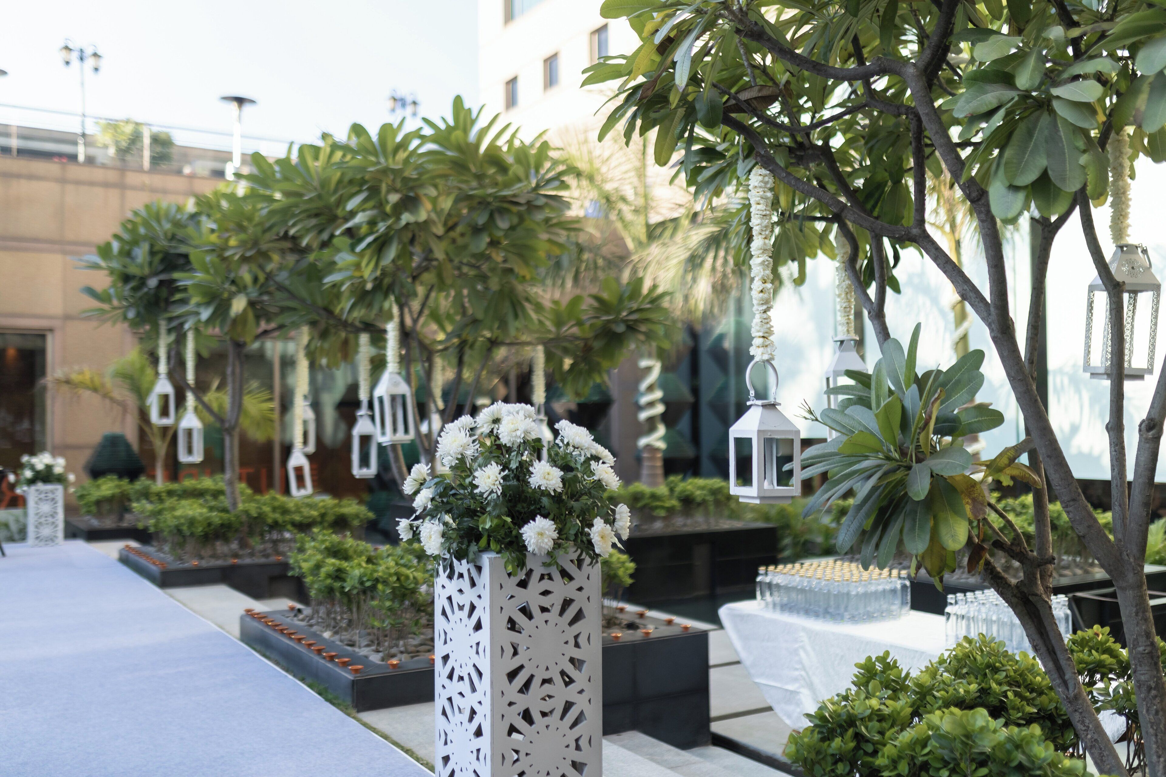 A well-maintained outdoor area with a pathway, decorative lanterns, and lush greenery.