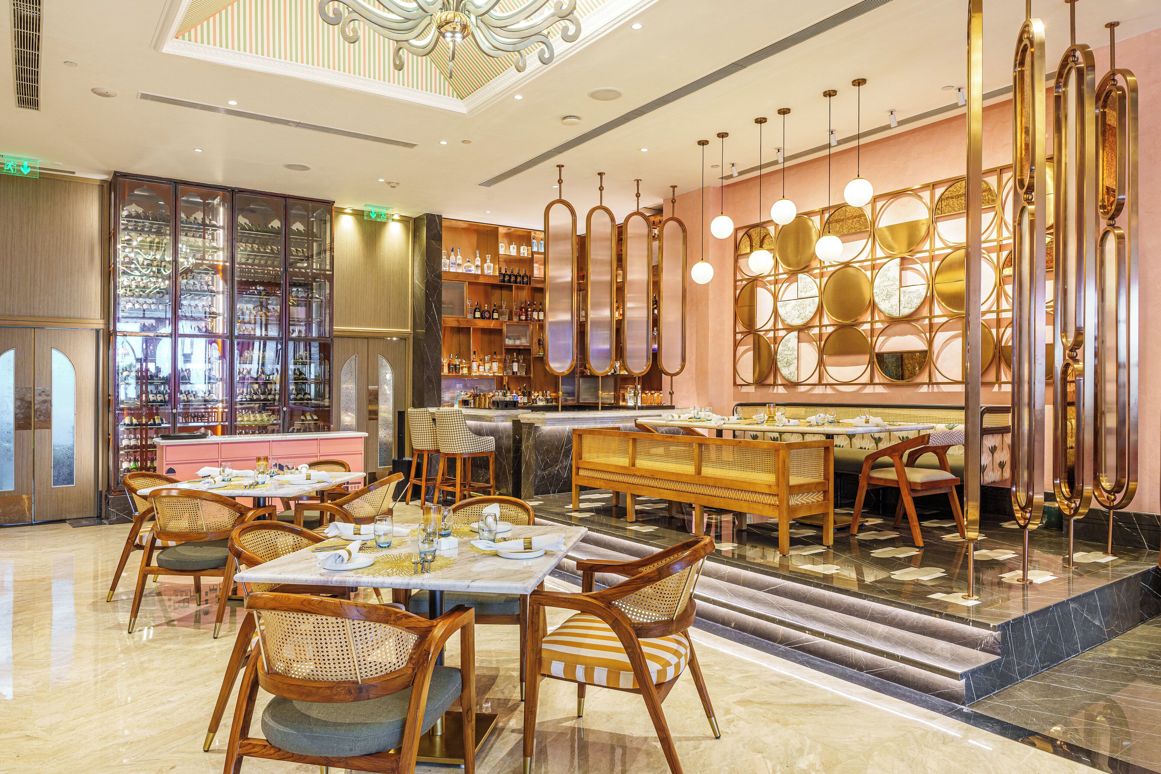 A modern restaurant with wooden furniture, a bar area, and a decorative wall with circular patterns.