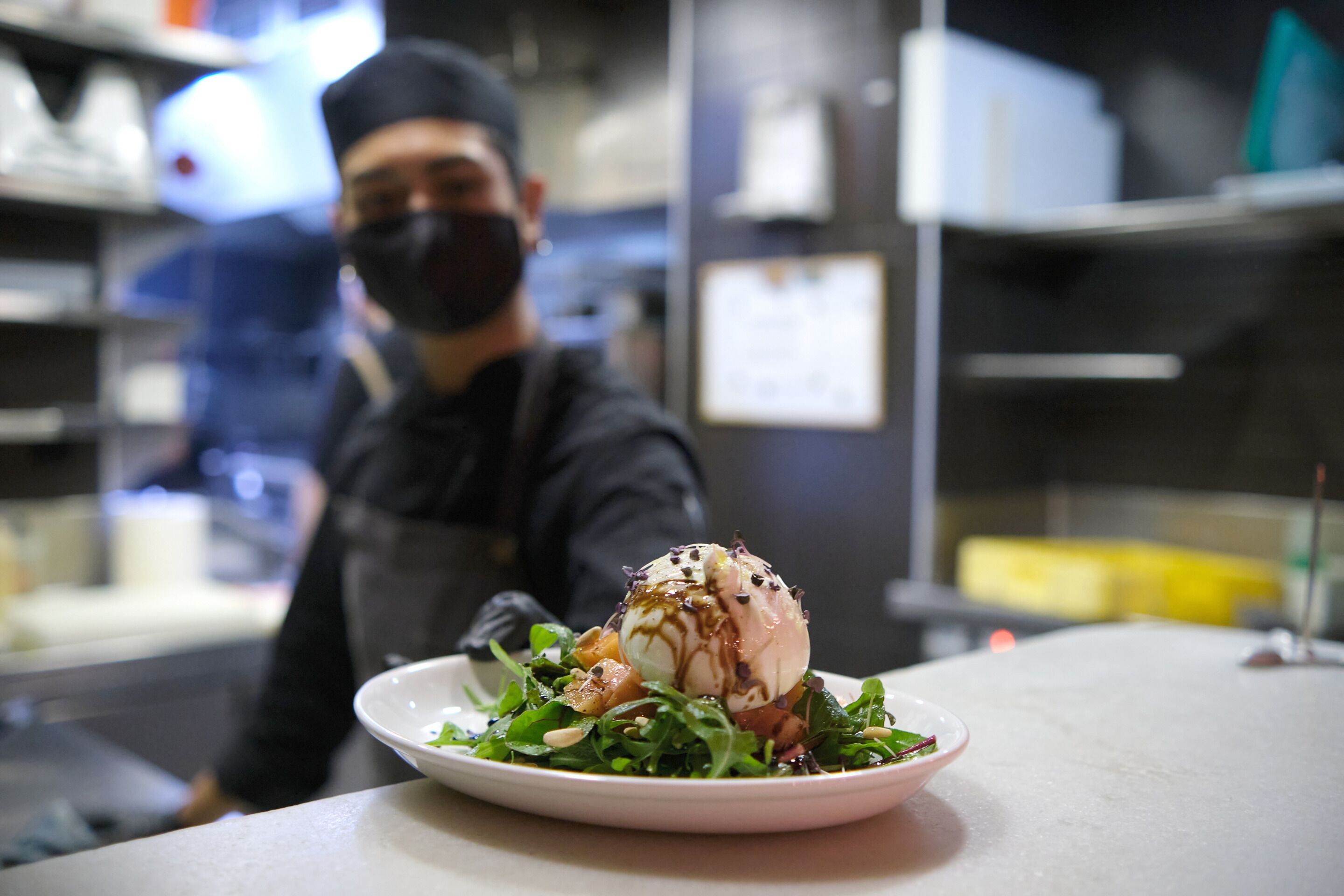 A dessert on a plate with a person in the background.