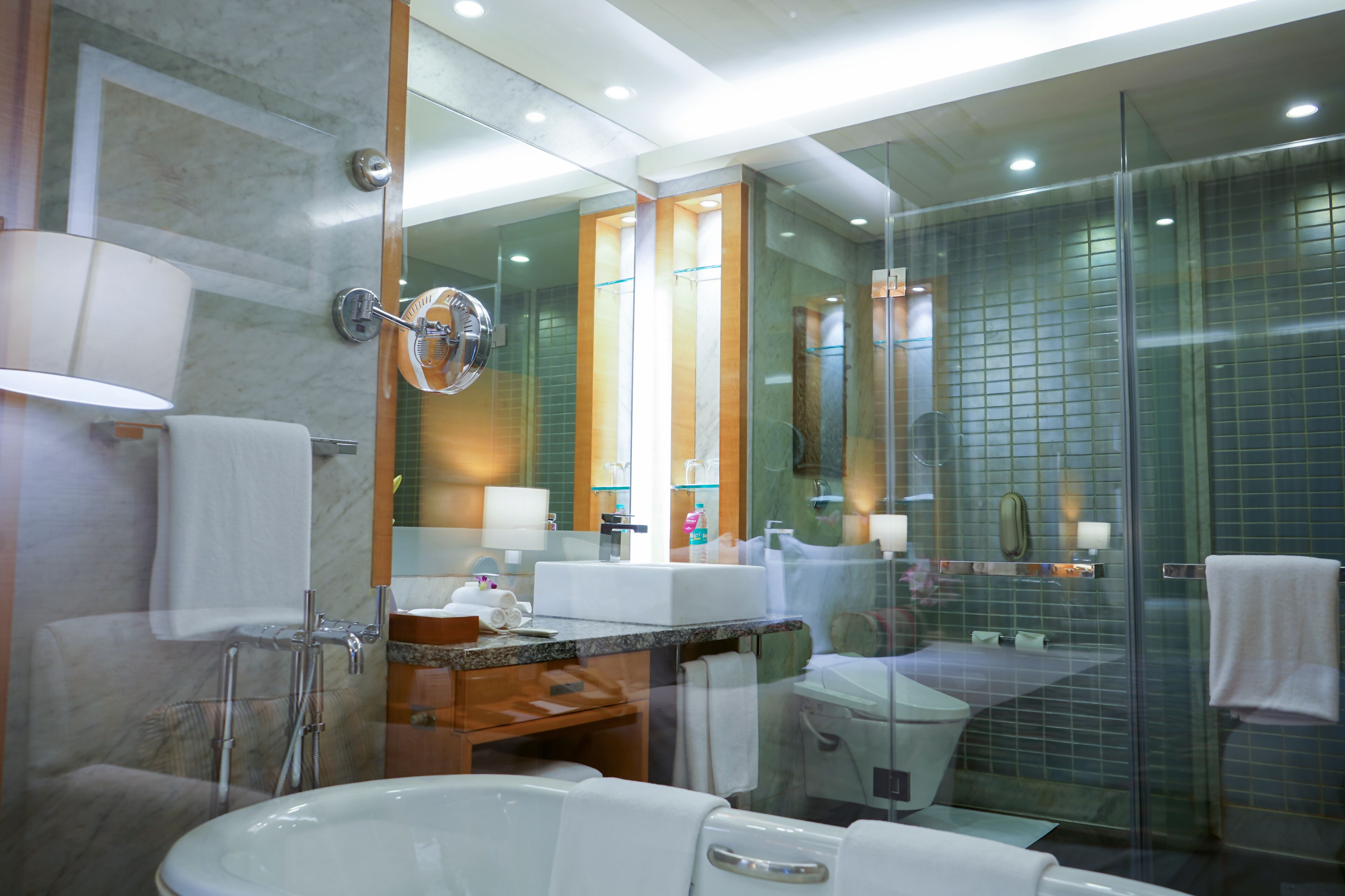 Une salle de bain moderne dotée d’une douche à parois de verre, d’une grande baignoire et d’un meuble-lavabo avec un miroir.