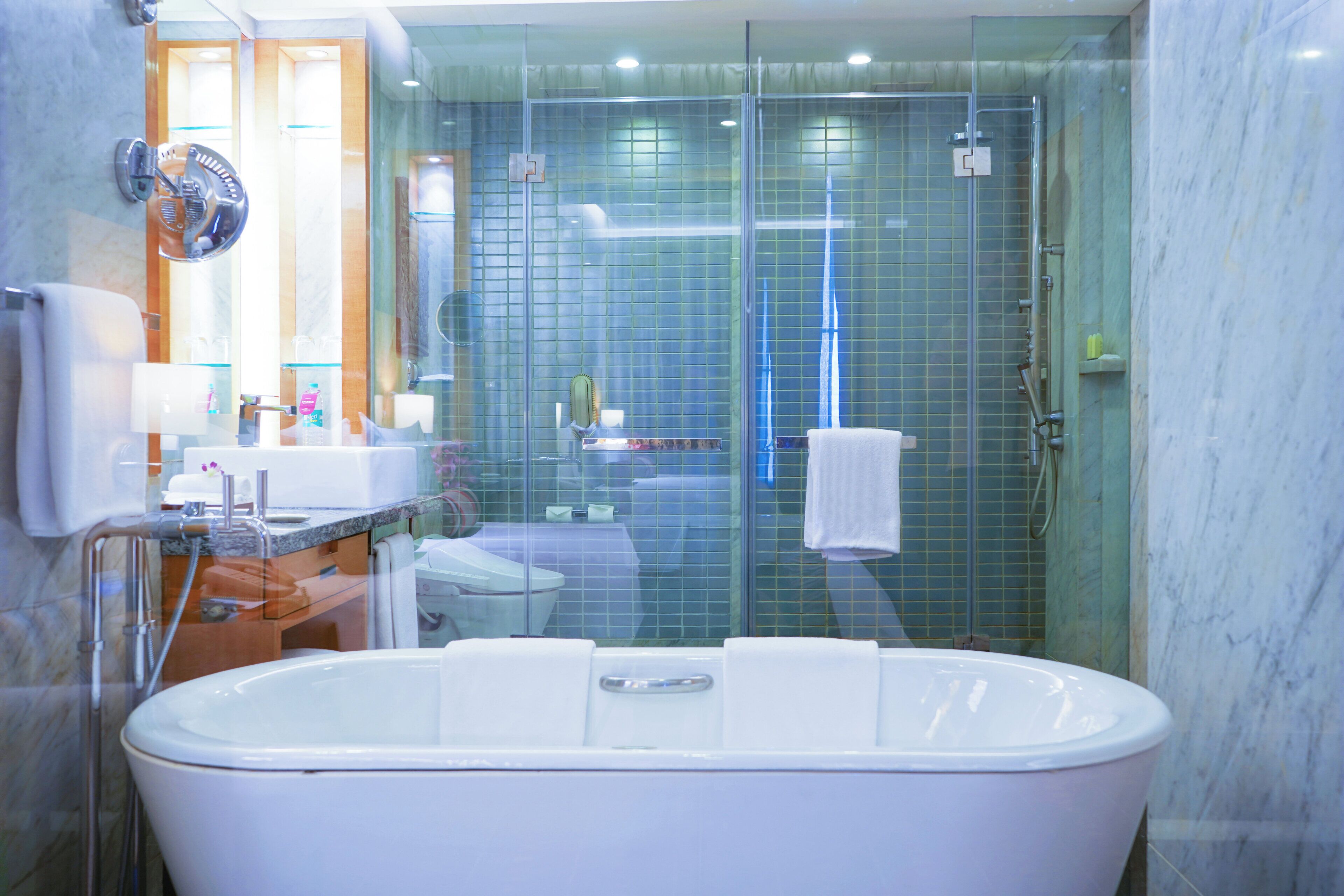 A modern bathroom with a freestanding bathtub, a glass-enclosed shower, and a vanity with a mirror and sink.