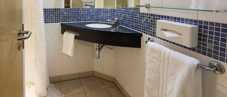 A bathroom with a sink, mirror, and towel rack.