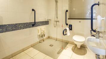 Un baño moderno con ducha, inodoro y lavamanos.