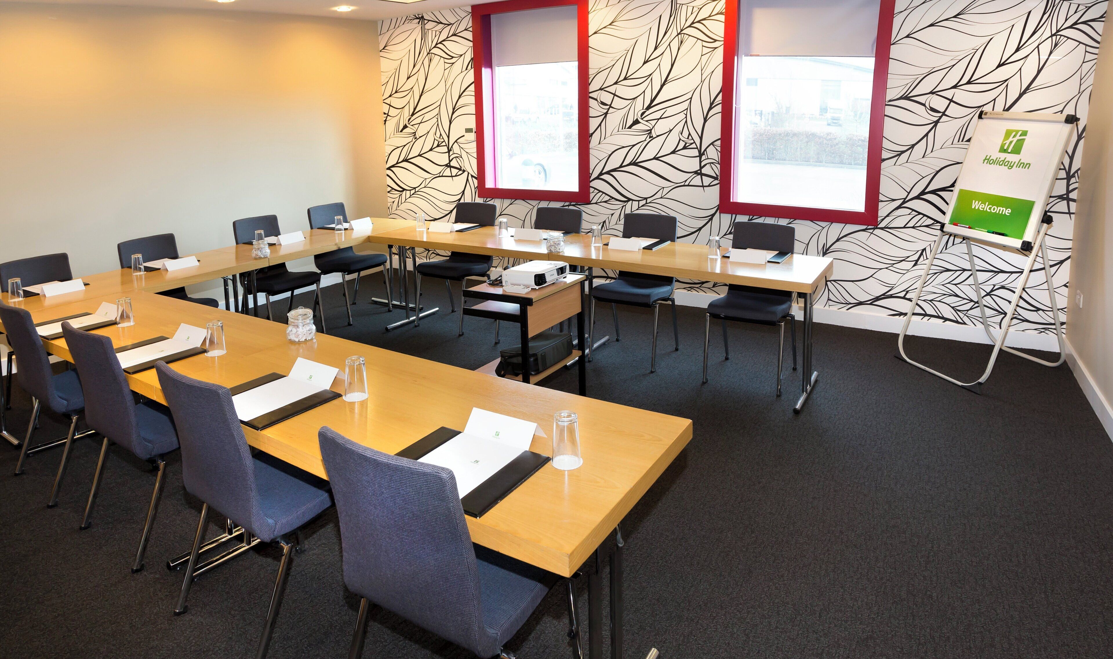 A conference room with a long table, chairs, and a projector.