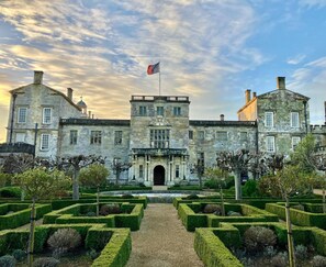 A historic building with a symmetrical facade, a central entrance, and a formal garden with geometrically trimmed hedges. - Holiday Inn Salisbury - Stonehenge by IHG (Salisbury)