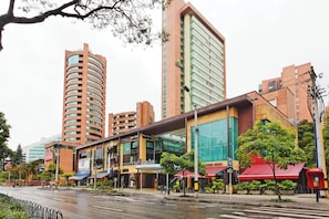 A multi-story hotel with a modern design, featuring a prominent glass facade and a curved structure. - Holiday Inn Express Medellin by IHG (Medellín)
