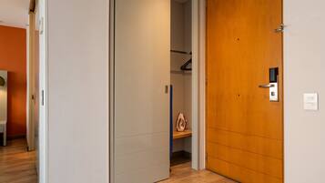 Un pasillo con una puerta de madera y un armario blanco con un estante.