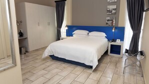 Une chambre bien rangée, avec un lit, des tables de chevet et une armoire.