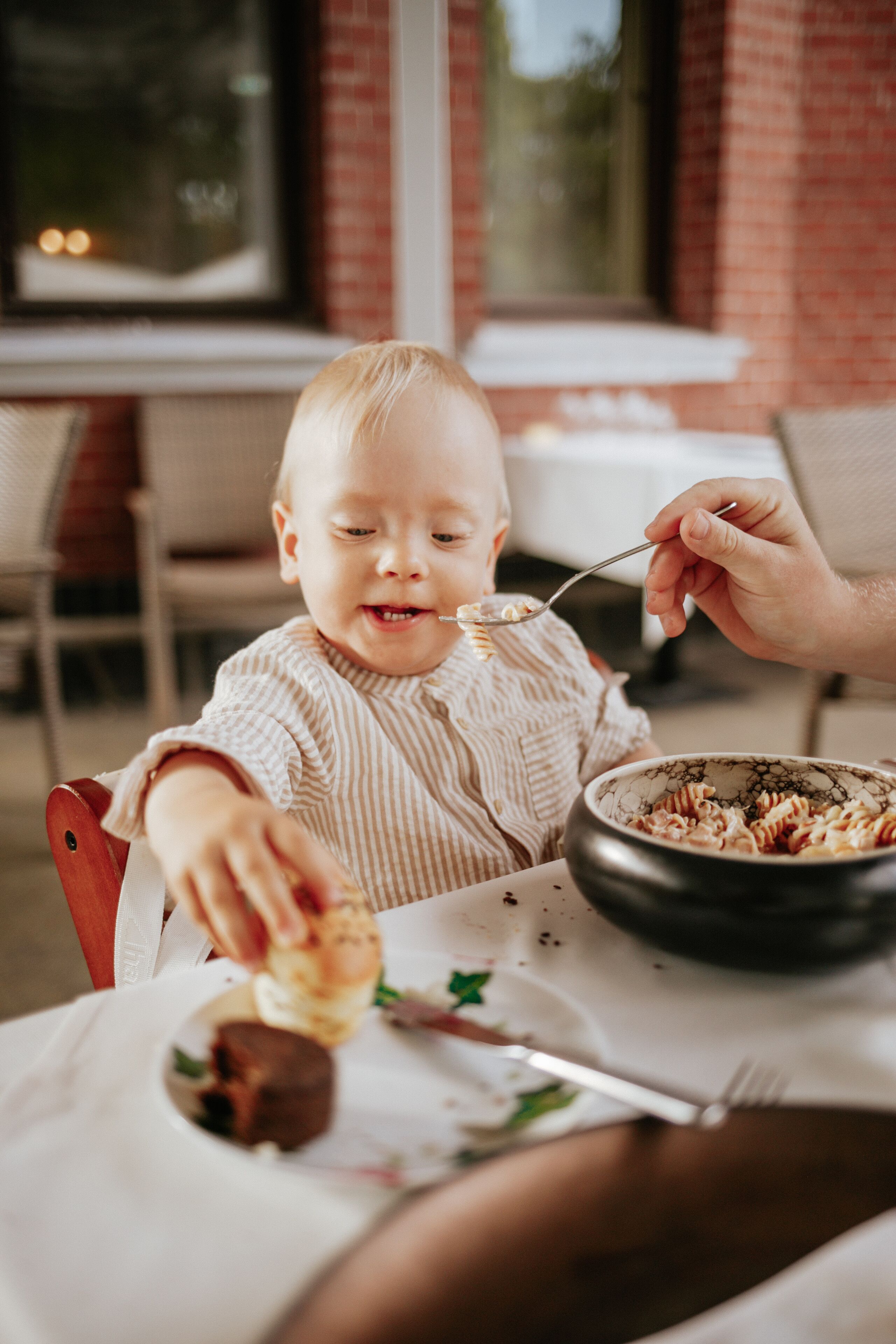 A dining table with a bowl of food and a spoon.