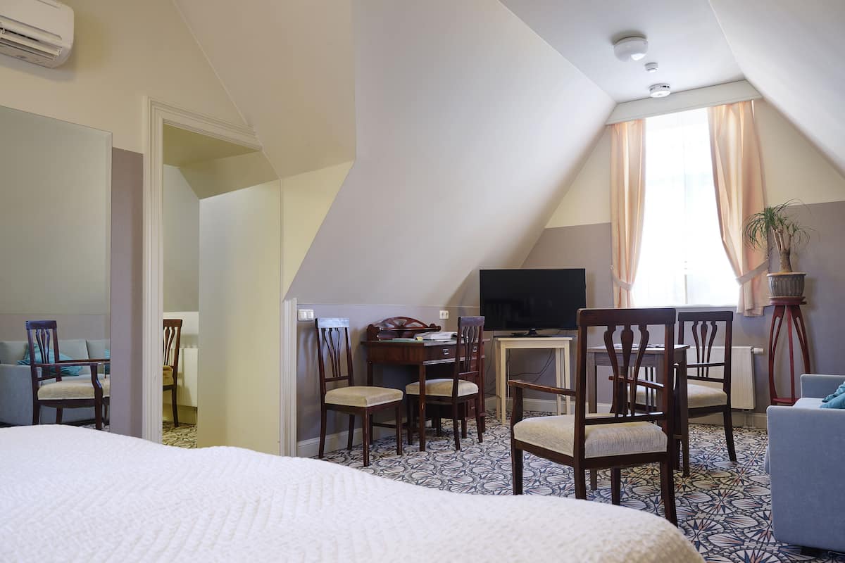 Une chambre d’hôtel comprenant un lit, un bureau avec une télévision et un coin repas.