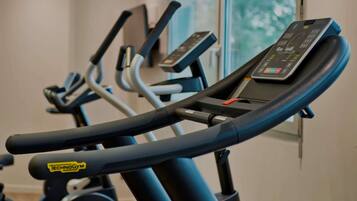 A row of stationary bikes with digital displays, likely in a gym setting.
