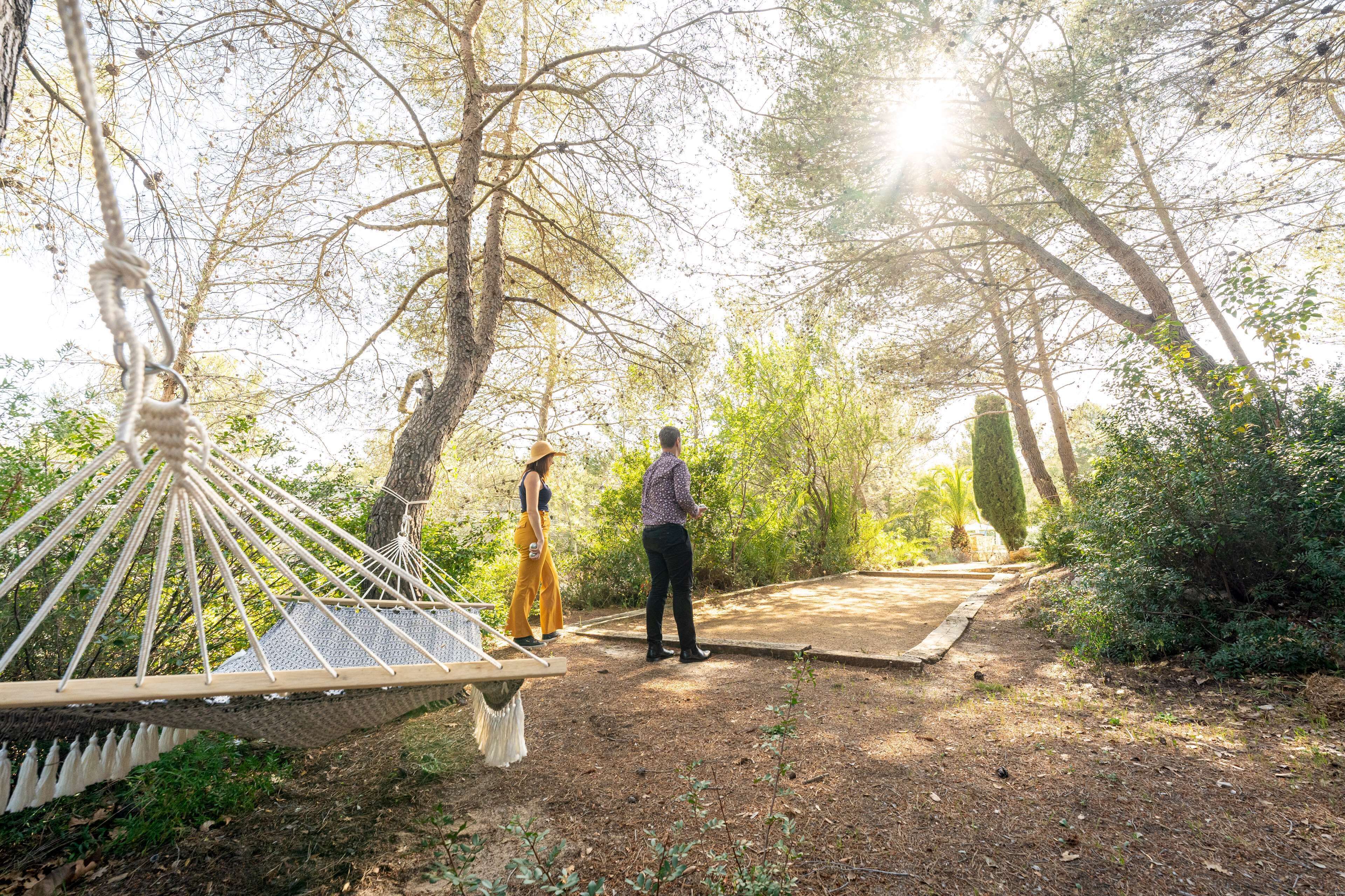 A hammock and a wooden deck in a wooded area.