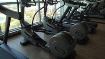 Uma academia com esteiras, elípticos e aparelhos de musculação.