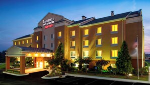 A multi-story hotel with a prominent entrance and a parking lot.
