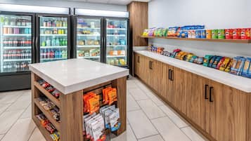Een snackbar met gekoelde drankjes, snacks en verpakte producten.
