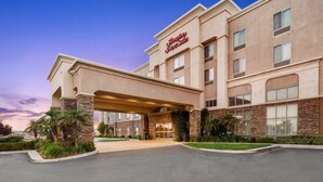 Ein Hampton Inn Hotel mit moderner Fassade, Steinverzierungen und einem gepflegten Eingangsbereich.