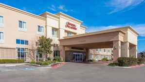 A Hampton Inn & Suites building with a clear blue sky.