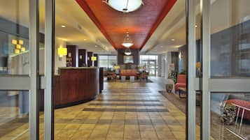 Un hall de hotel con mostrador de recepción, zona de estar y mostrador de check-in.