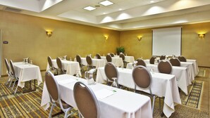A conference room with tables set for meetings, equipped with chairs and water pitchers. - Holiday Inn & Suites Green Bay Stadium by IHG (Green Bay)