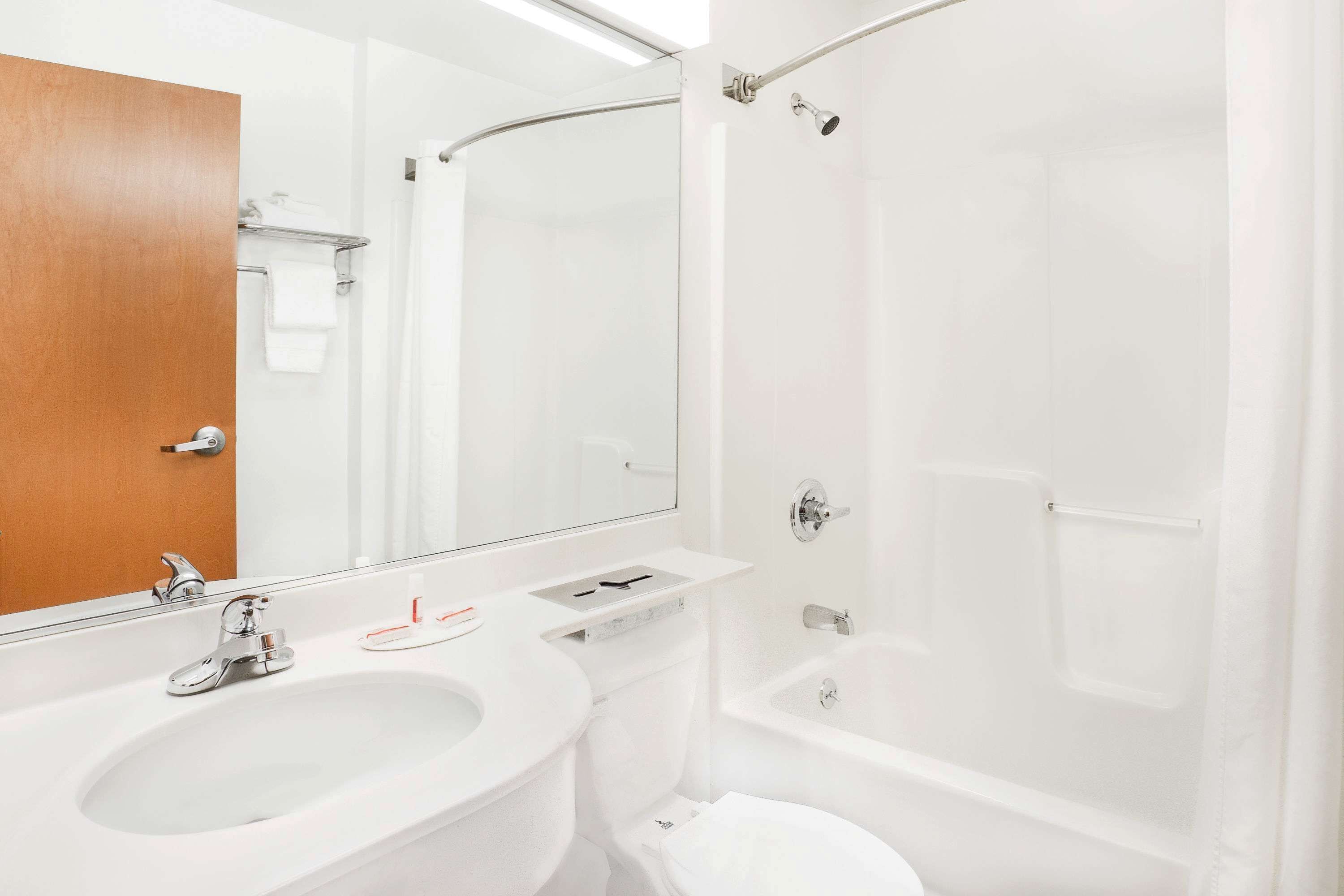 A modern bathroom with a sink, toilet, and shower.