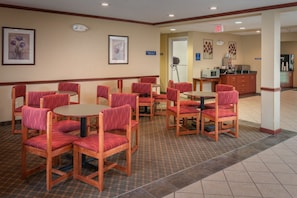 Relax in the hotel lobby's inviting seating area, surrounded by framed artwork and a stylish tile floor.