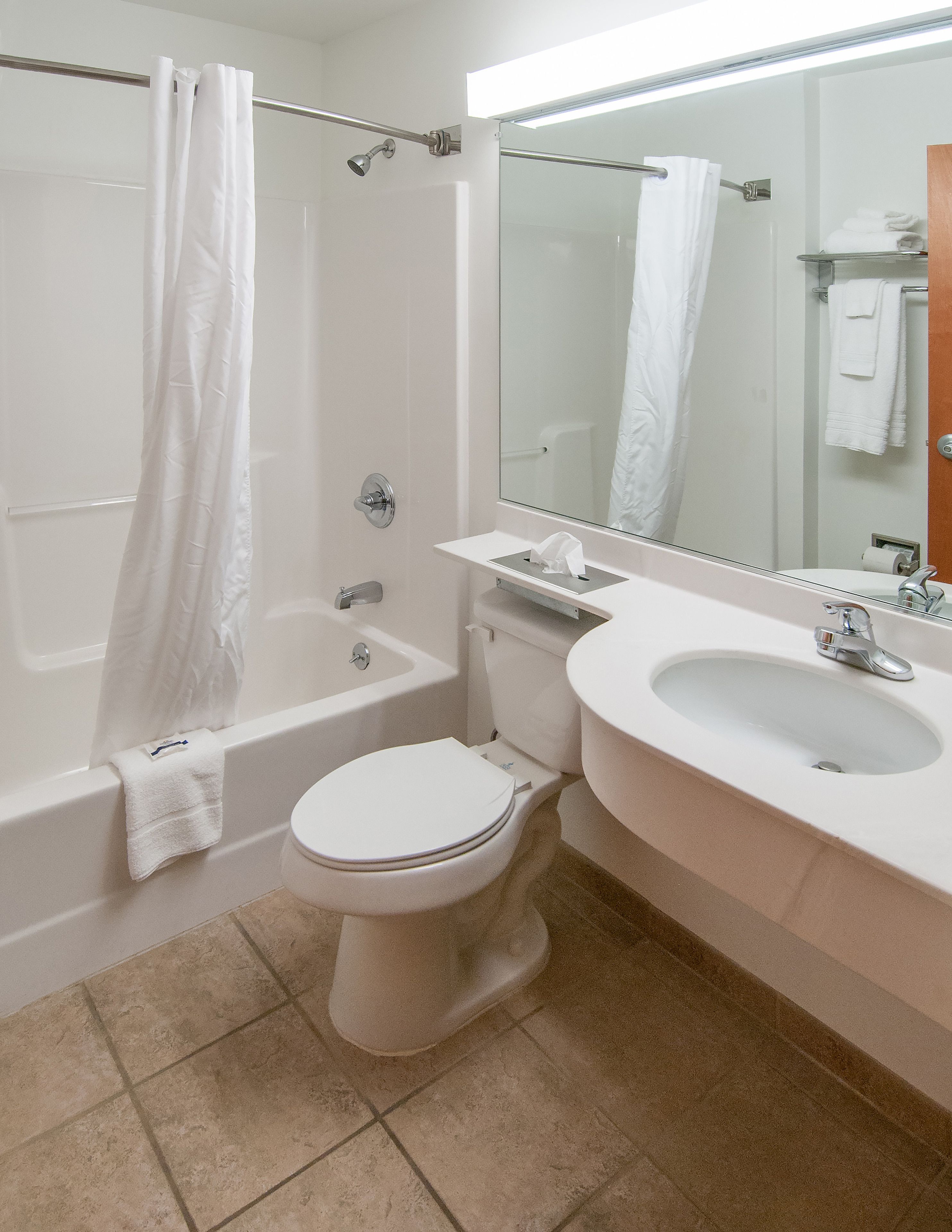 A bathroom with a bathtub, toilet, and sink.
