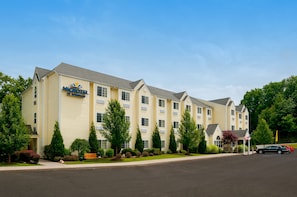 Stylish hotel with a multi-story design, surrounded by beautifully maintained gardens and a convenient parking area.