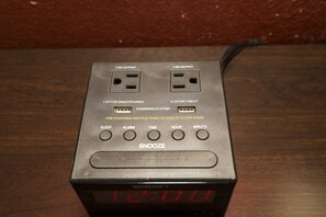 Una sveglia digitale Sonnet nera con display che segna le 12:00, porte di ricarica USB e un tasto snooze.