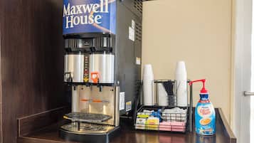 Una cafetera con una cápsula de café 'Maxwell House', un recipiente para goteo y una botella de crema de café 'French Vanilla'.