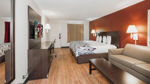 A hotel room with a bed, a desk, a chair, a sofa, and a TV. - Red Roof Inn Walterboro (Walterboro)