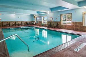 Una piscina con muelle de baldosas, sillas y un letrero que indica una profundidad de 3 pies.