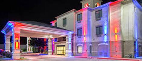 Un hotel con un espacio exterior techado y varios pisos.