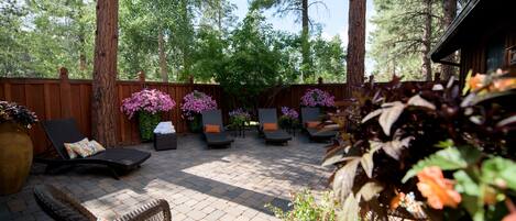 An outdoor patio area with lounge chairs and a wooden fence.