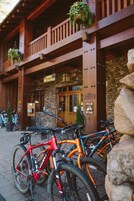 Entrada a un albergue con fachada de madera, un letrero que dice "Lodge Entrance" y un muro de piedra.
