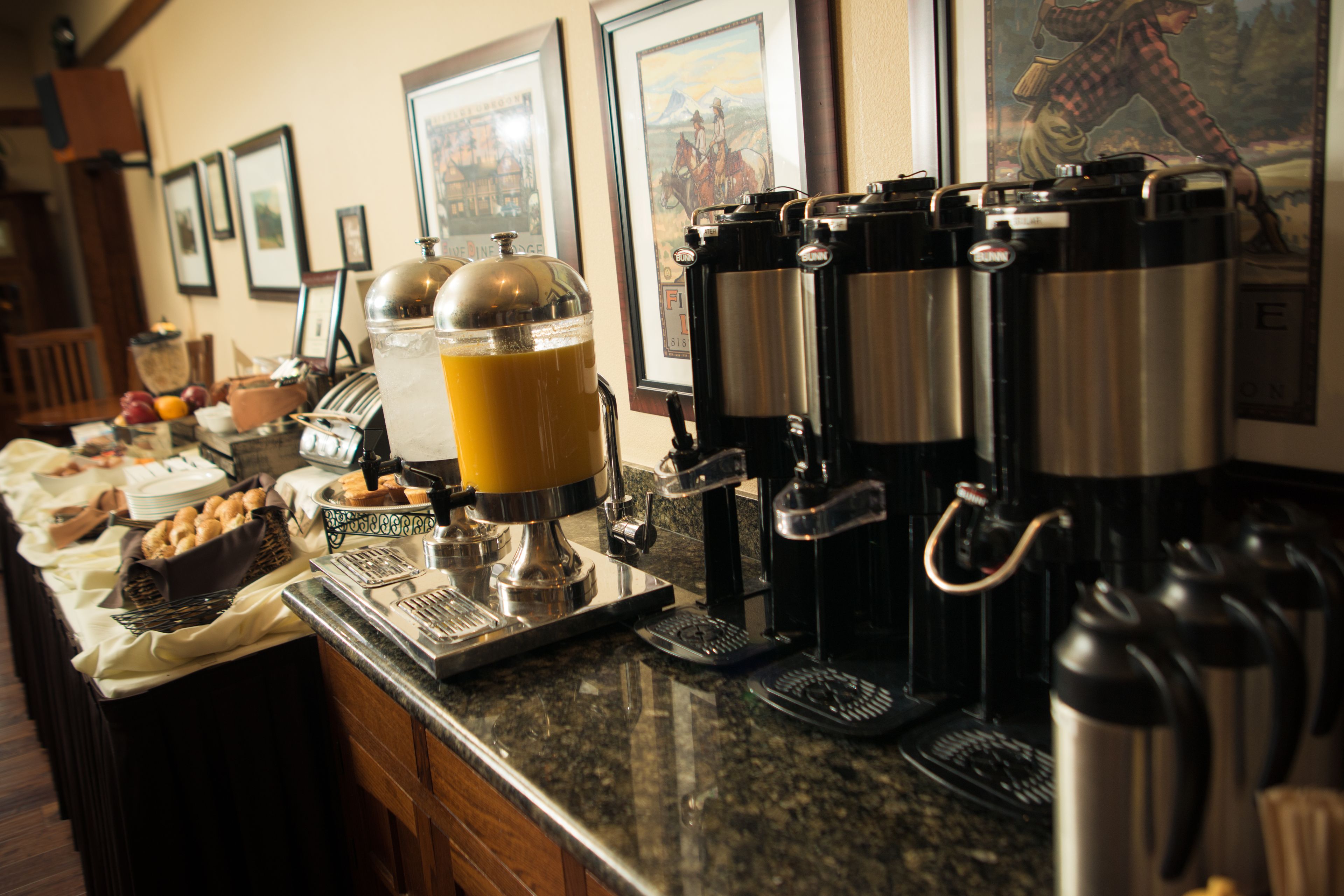 A buffet setup with coffee machines and a juice dispenser.