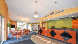 Eine Hotelhalle mit Rezeption, Sitzgelegenheiten und einem großen Fenster.