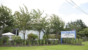 A hotel with a sign reading "Dew Drop Inn" and "Welcome Spring has Sprung".