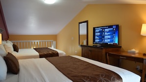 A hotel room with two beds, a desk, a television displaying a sports game, and a mirror on the wall.