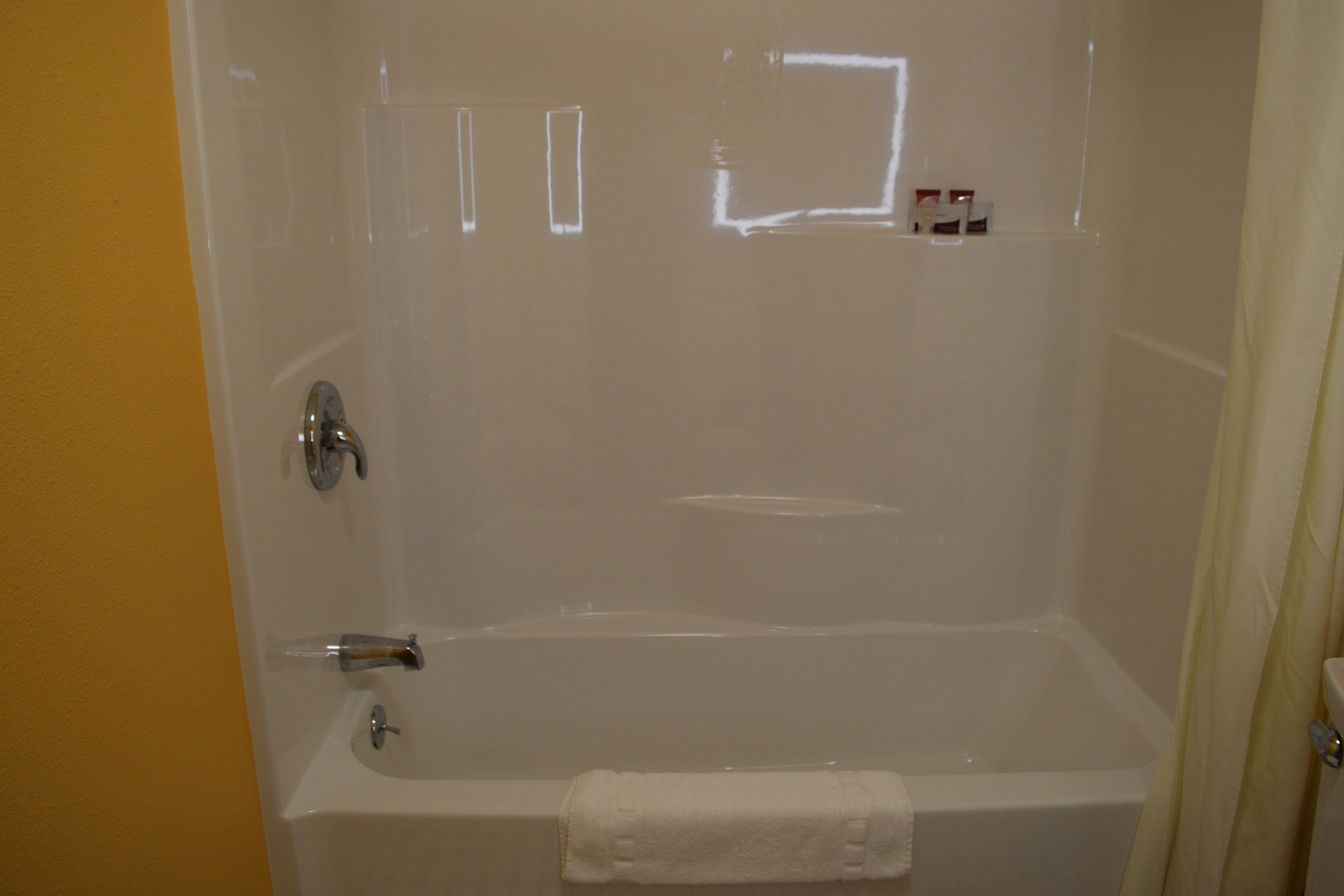 A bathroom with a bathtub, a shower area, and a toilet.