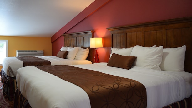 A hotel room with two beds, a red accent wall, and a modern design. - The Dew Drop Inn Motel (Forks)