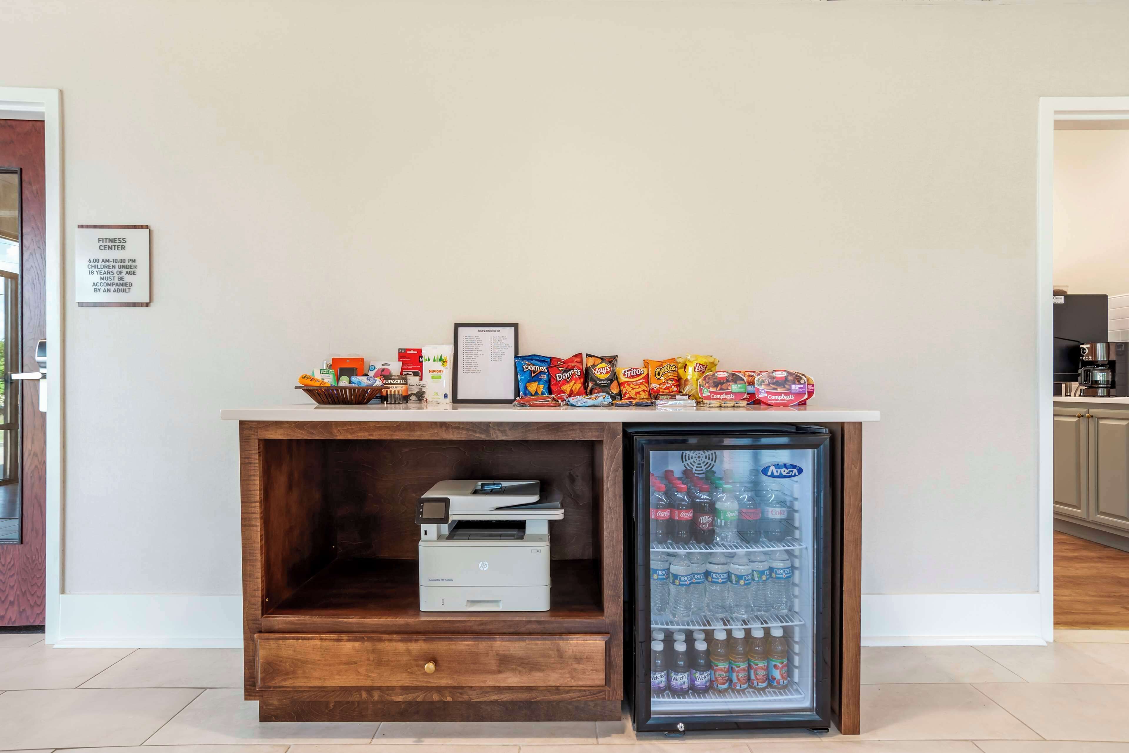 Una pequeña zona de cocina con refrigerador, microondas y cafetera.