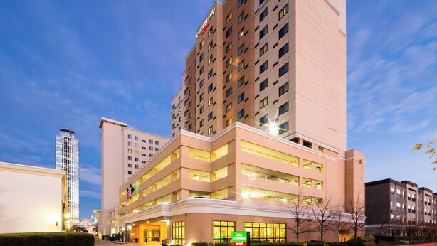 A multi-story hotel with a prominent 'Courtyard' sign, featuring a modern architectural design with large windows and a flat roof.