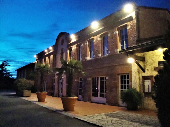 A brick building with multiple windows and a paved sidewalk. - Best Western Plus Le Canard Sur le Toit (Colomiers)