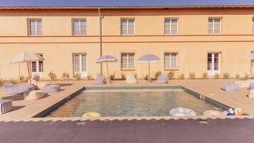 Alberca al aire libre por temporada y sombrillas en la alberca