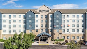Un hotel Staybridge Suites con fachada simétrica, varios ventanales y una entrada central.