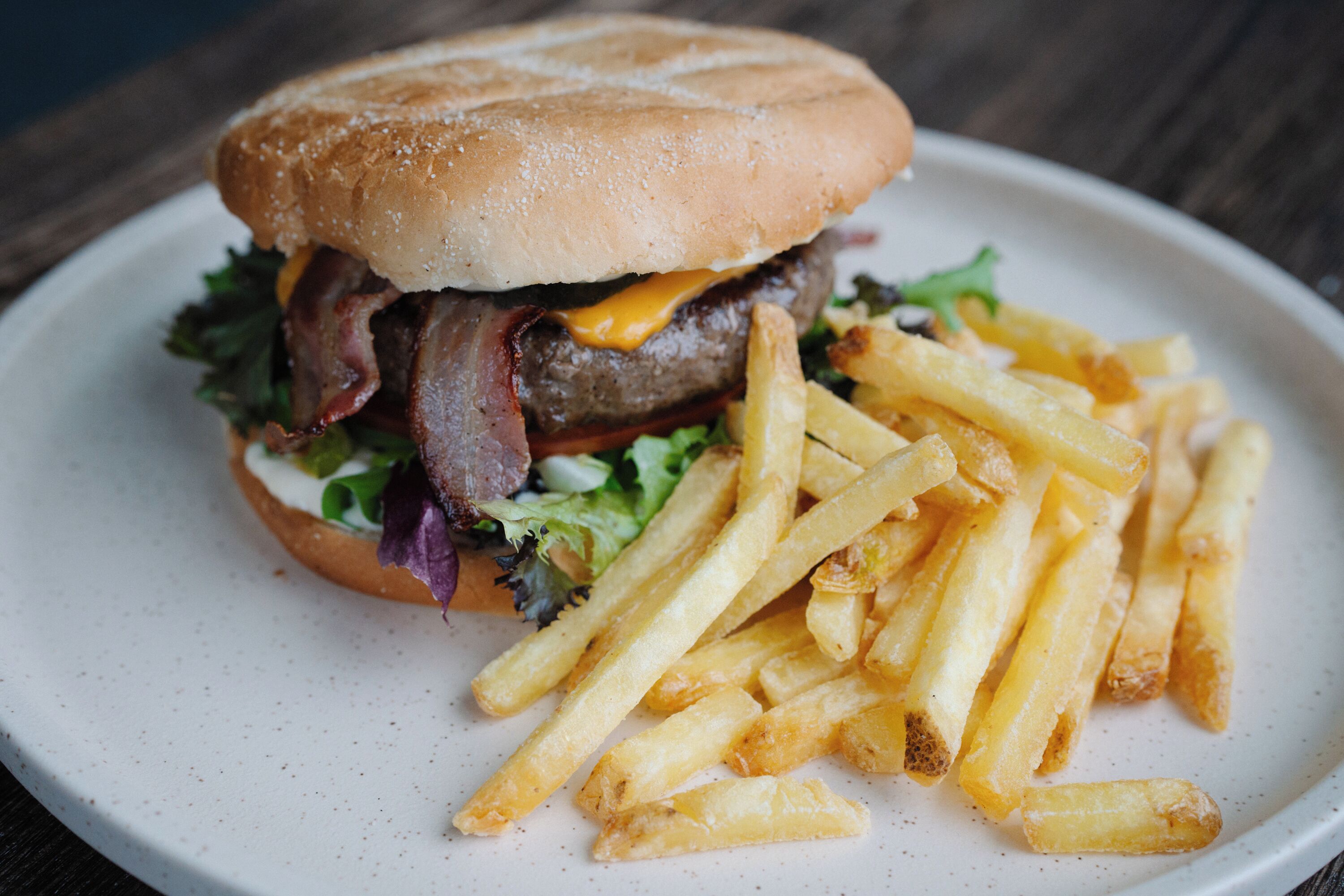 Una hamburguesa con papas fritas en un plato.