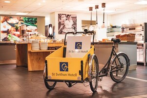 Un carrito de reparto en bicicleta con un letrero del Hotel San Swithun en la zona de la cocina del hotel.