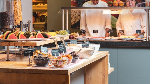Un bufé con diferentes opciones de comida y una máquina de café.