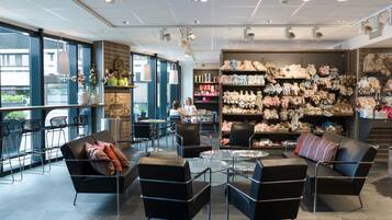 Een modern interieur met zithoeken, een koffiebar en een muur vol pluchen knuffels.