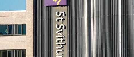 A modern building with a prominent sign for St. Swithun Hotel.